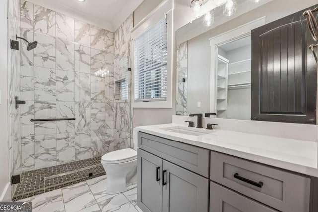 bathroom with marble finish floor, toilet, a shower stall, and vanity