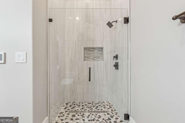 bathroom with a stall shower and baseboards