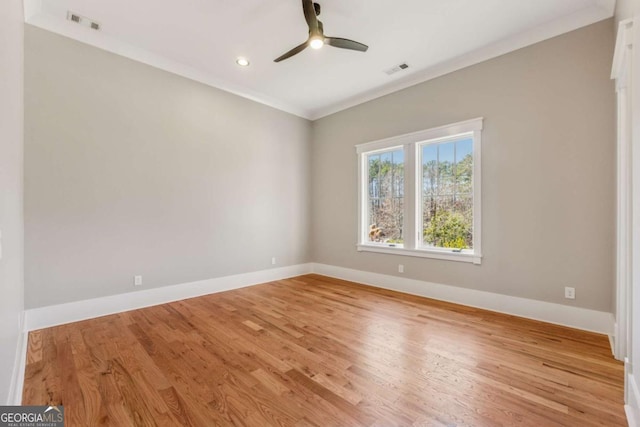 spare room featuring baseboards, visible vents, ceiling fan, crown molding, and light wood-type flooring