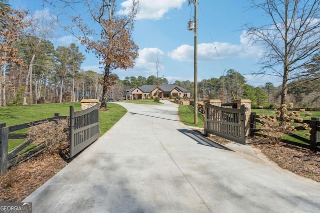 view of road with concrete driveway, a gated entry, and a gate