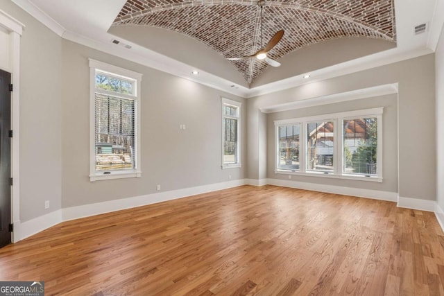 unfurnished living room with brick ceiling, light wood-style floors, crown molding, and baseboards