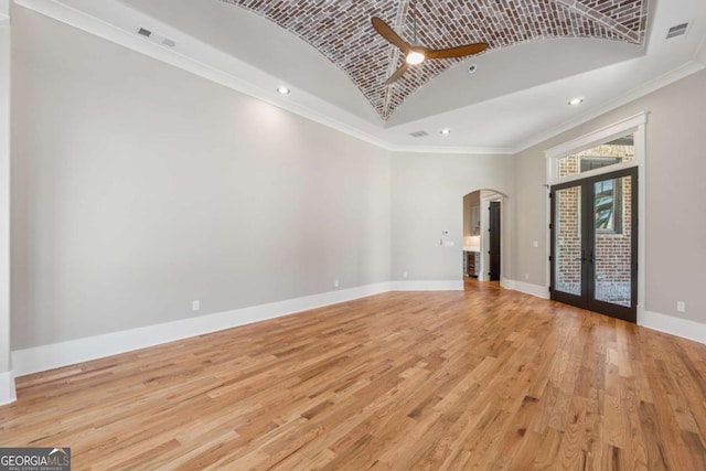 unfurnished living room featuring visible vents, baseboards, arched walkways, light wood-type flooring, and recessed lighting