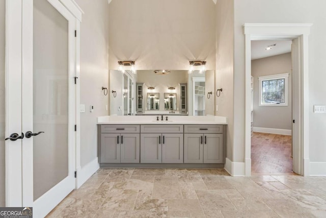 bathroom featuring stone finish floor, vanity, and baseboards