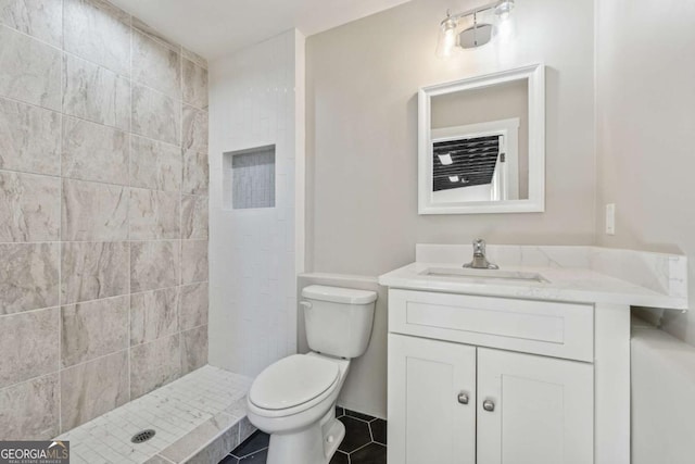 bathroom featuring toilet, a stall shower, tile patterned flooring, and vanity