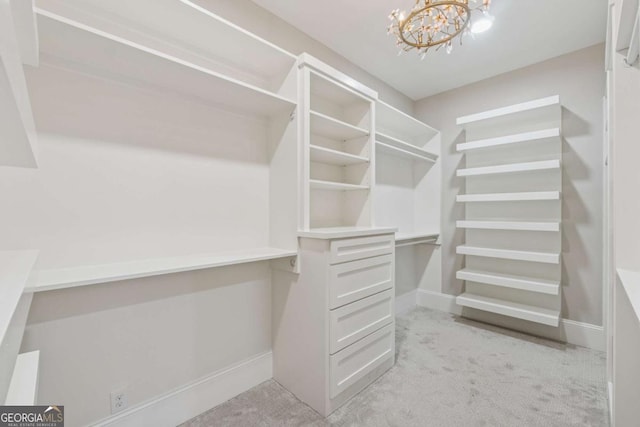 walk in closet featuring light carpet and a notable chandelier