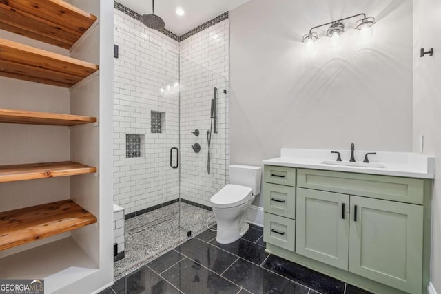 bathroom with toilet, a shower stall, and vanity