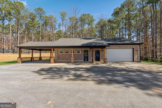 view of front facade with driveway, a garage, and brick siding