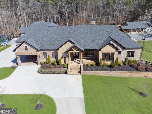 view of front of house featuring driveway, brick siding, a chimney, and a front yard