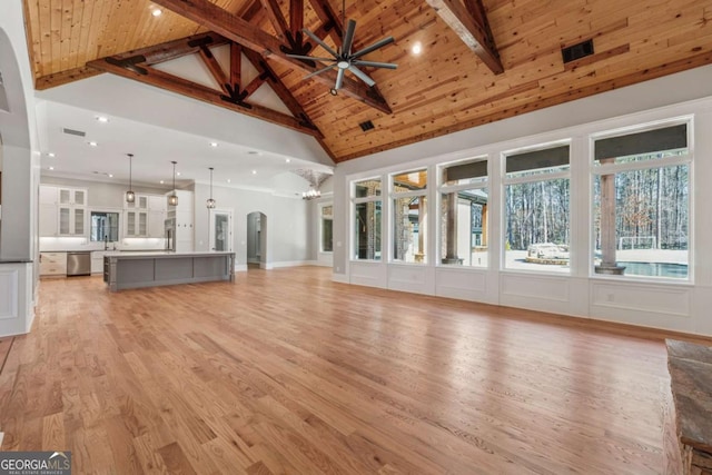 unfurnished living room featuring wood ceiling, high vaulted ceiling, light wood-type flooring, beamed ceiling, and ceiling fan with notable chandelier