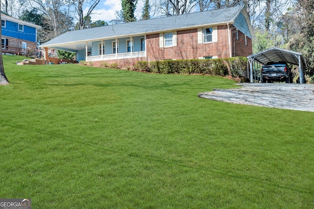 view of front of home with a carport, brick siding, driveway, and a front lawn