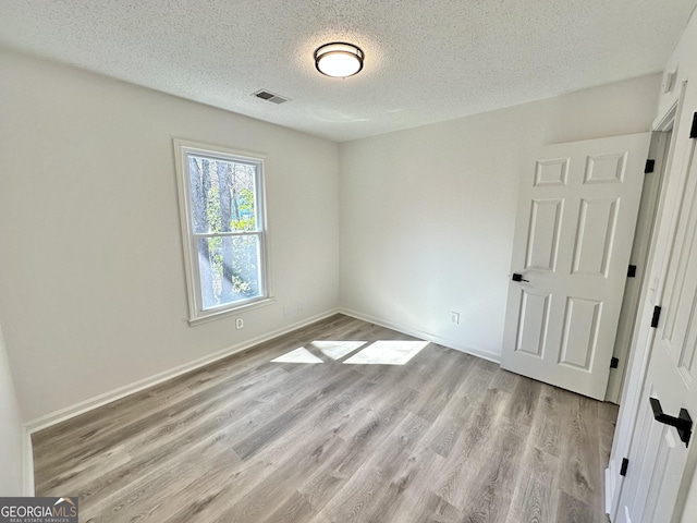 101 Summer Pond Trl, Lawrenceville, GA 30046 - unfurnished room featuring a textured ceiling, light wood-type flooring, and baseboards