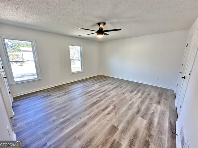 101 Summer Pond Trl, Lawrenceville, GA 30046 - unfurnished room featuring a textured ceiling, healthy amount of natural light, wood finished floors, ceiling fan, and baseboards