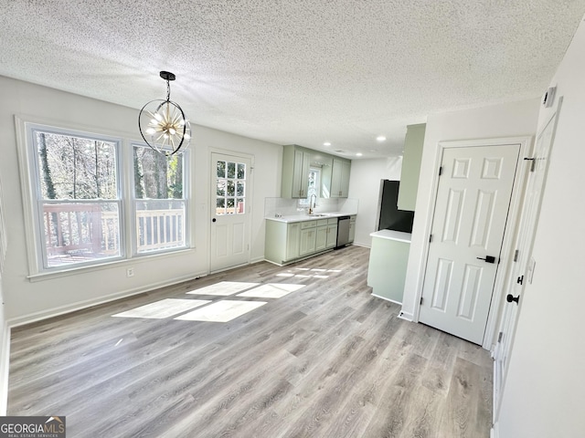 101 Summer Pond Trl, Lawrenceville, GA 30046 - unfurnished living room with light wood-style floors, a sink, a textured ceiling, a chandelier, and recessed lighting