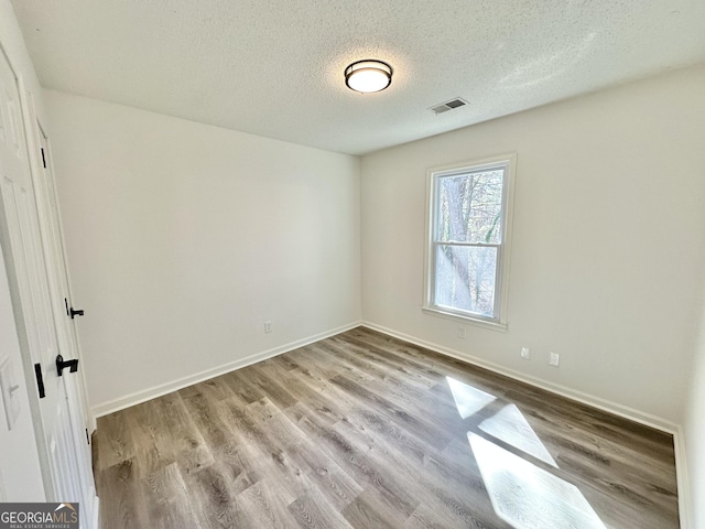 101 Summer Pond Trl, Lawrenceville, GA 30046 - empty room featuring a textured ceiling, wood finished floors, and baseboards