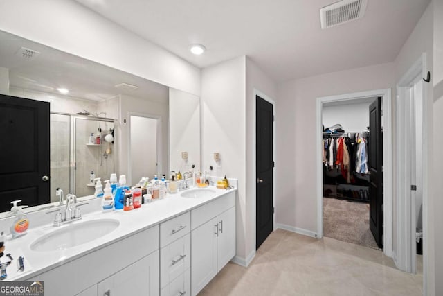 full bathroom with a sink, visible vents, a spacious closet, double vanity, and a stall shower