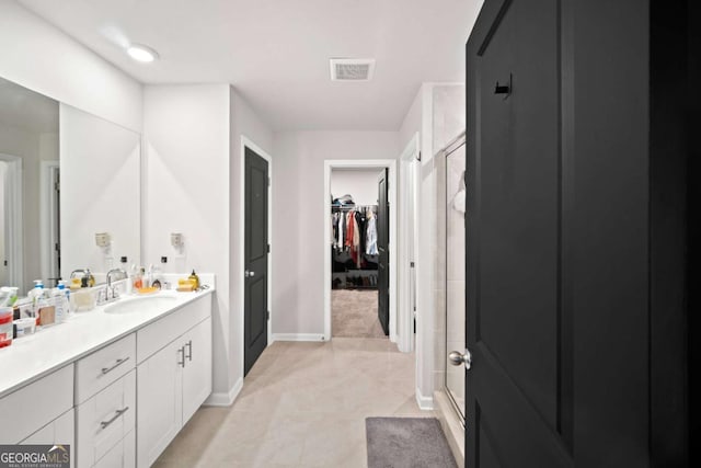 bathroom with visible vents, tile patterned floors, a spacious closet, vanity, and a shower stall