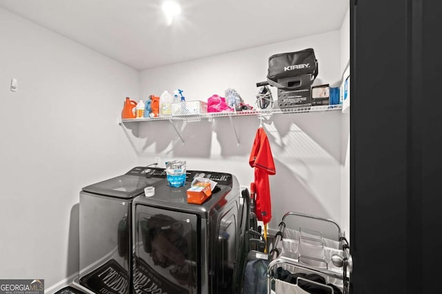 washroom with laundry area, baseboards, and washer and clothes dryer