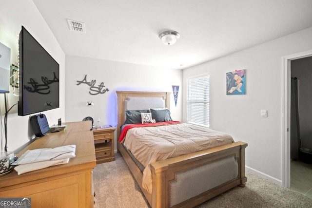 bedroom with light carpet, visible vents, and baseboards