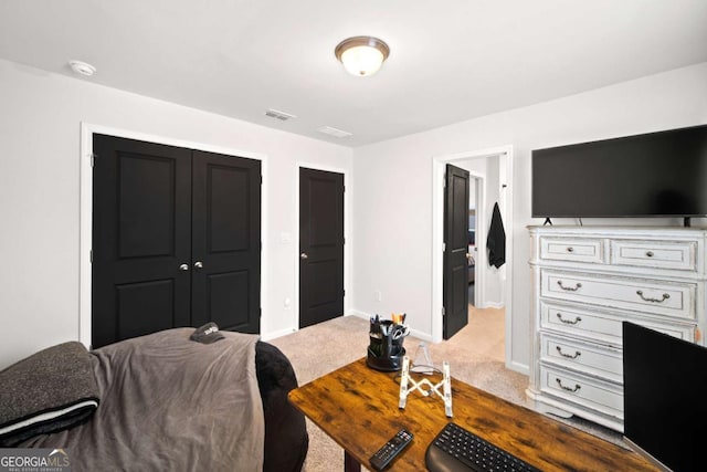 carpeted bedroom with visible vents, baseboards, and a closet