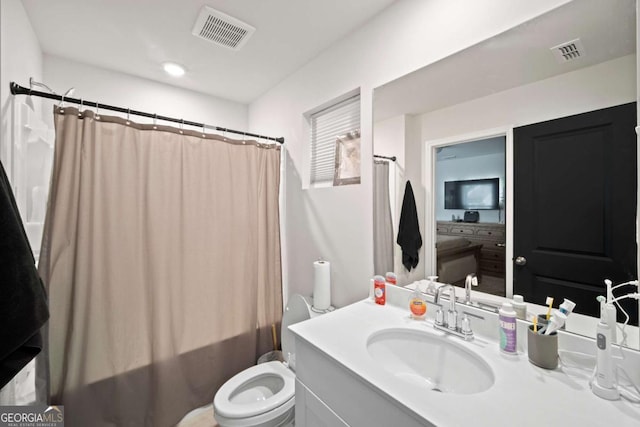 bathroom with visible vents, vanity, toilet, and shower / bath combo with shower curtain