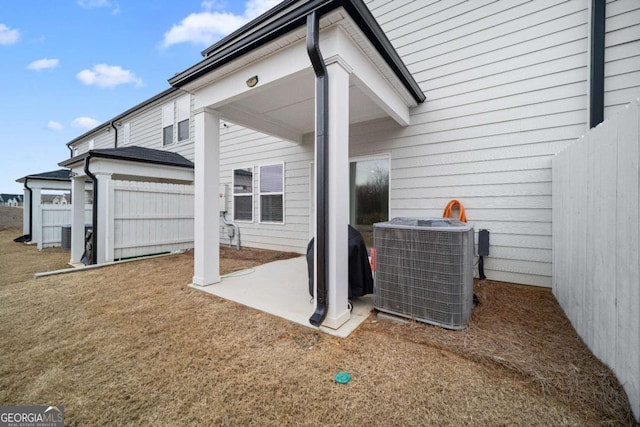 exterior space featuring a patio, central AC unit, a lawn, and fence