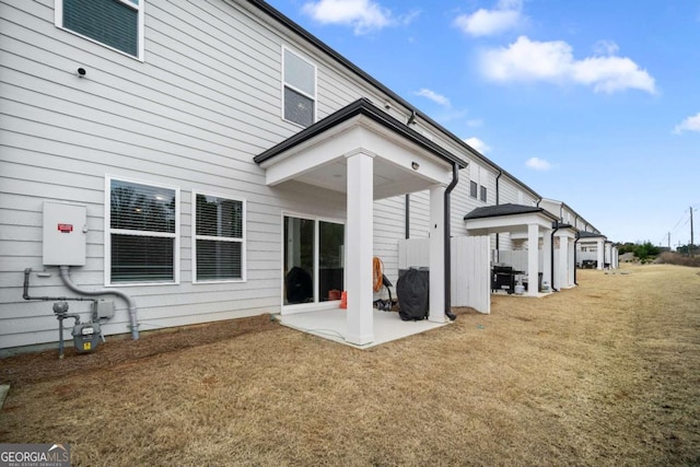 rear view of property featuring a yard and a patio