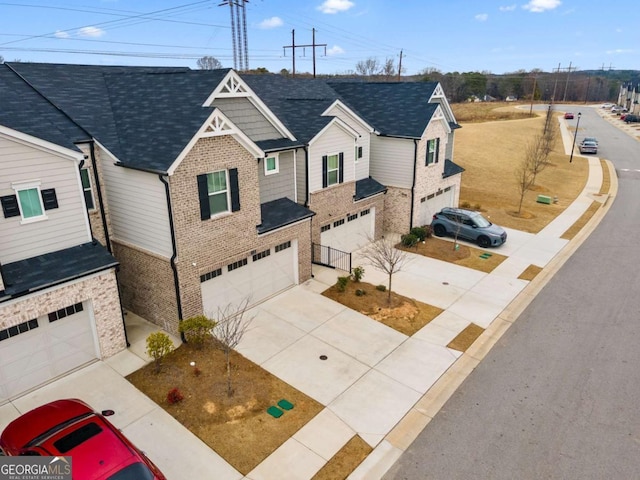 view of front of home with a garage, brick siding, and driveway