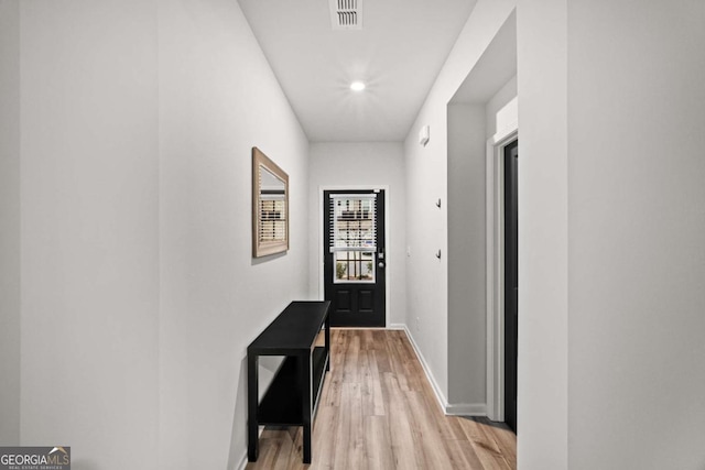 doorway featuring visible vents, light wood-style flooring, and baseboards