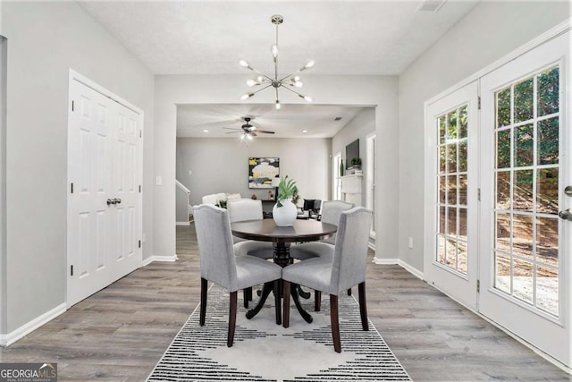 dining area featuring a chandelier, wood finished floors, and baseboards