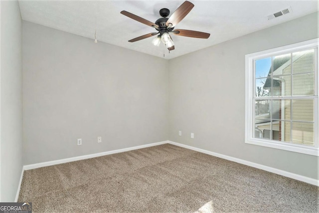 empty room featuring a ceiling fan, carpet, visible vents, and baseboards