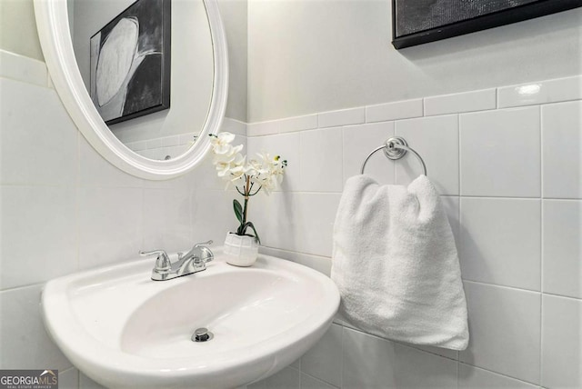 bathroom with tile walls and a sink