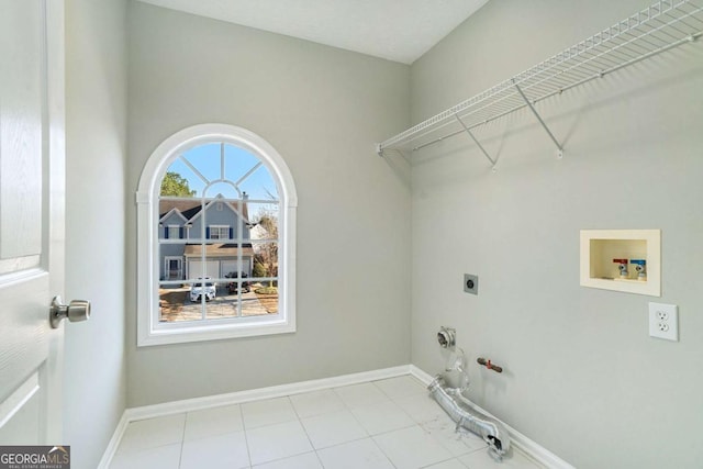 clothes washing area featuring hookup for a washing machine, hookup for a gas dryer, hookup for an electric dryer, laundry area, and baseboards