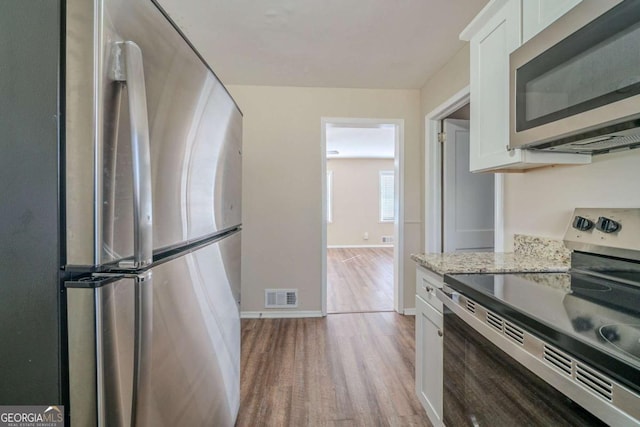 kitchen featuring white cabinetry, visible vents, appliances with stainless steel finishes, and light wood-style flooring