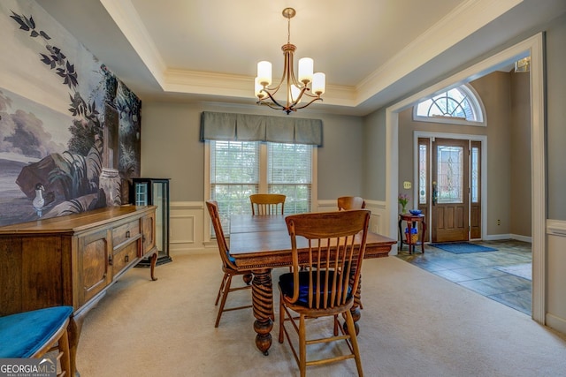 dining space with light carpet, a tray ceiling, and a healthy amount of sunlight