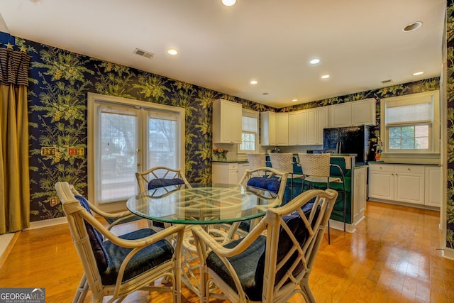 dining area featuring light wood-type flooring, wallpapered walls, visible vents, and recessed lighting