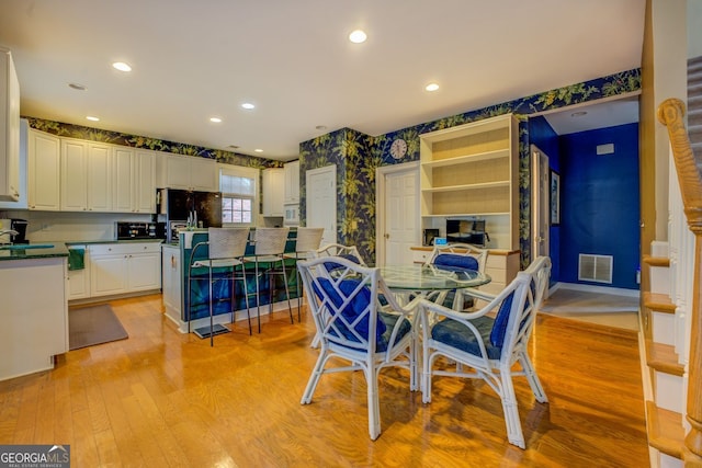 dining room featuring wallpapered walls, visible vents, baseboards, light wood-style flooring, and recessed lighting