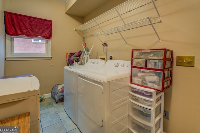 laundry area with laundry area, baseboards, washing machine and clothes dryer, and tile patterned floors