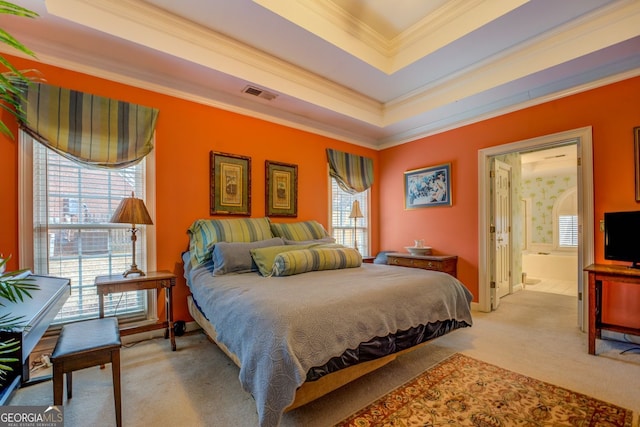 bedroom featuring a tray ceiling, visible vents, light carpet, and multiple windows