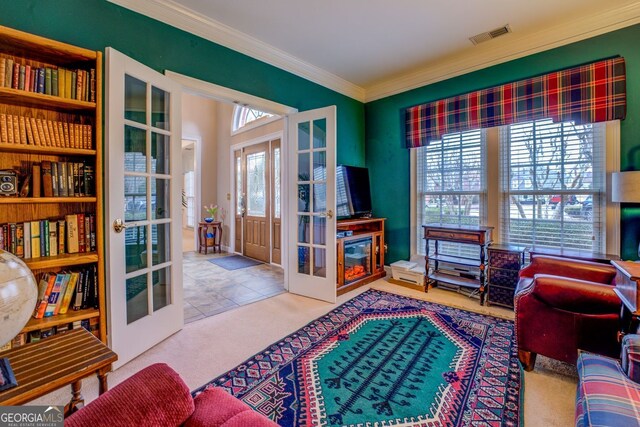 sitting room with carpet, visible vents, ornamental molding, and french doors