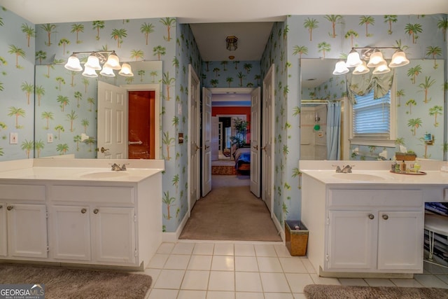 bathroom featuring a sink, a shower stall, ensuite bathroom, and wallpapered walls