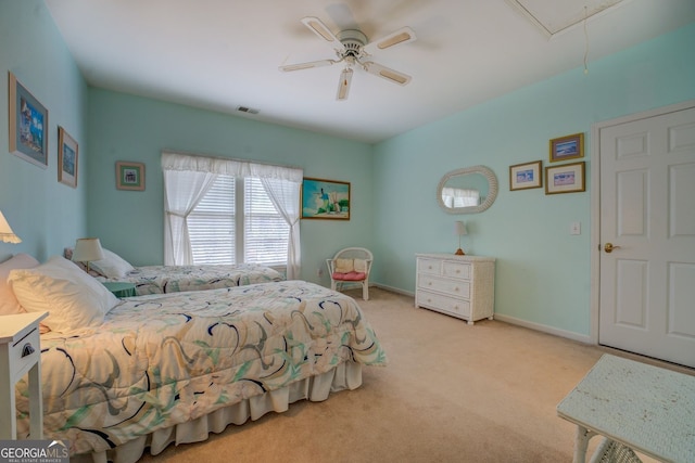 carpeted bedroom with visible vents, a ceiling fan, attic access, and baseboards