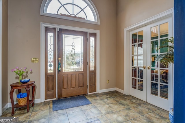 foyer entrance featuring french doors, a wealth of natural light, and baseboards