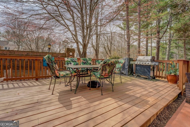 deck with a grill and outdoor dining area