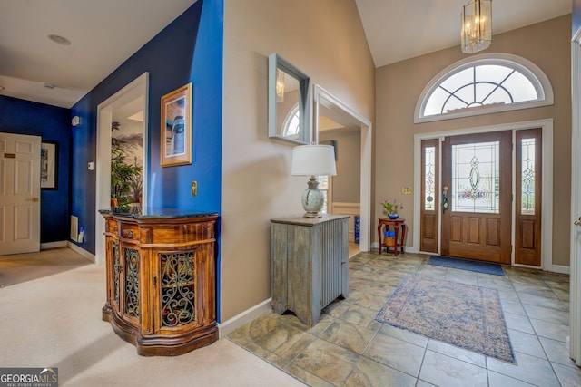 foyer entrance with lofted ceiling, an inviting chandelier, and baseboards