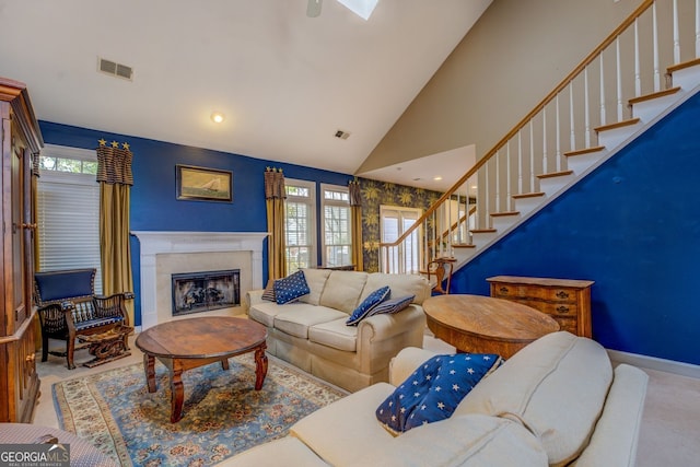 living area with carpet, a fireplace, visible vents, stairway, and high vaulted ceiling