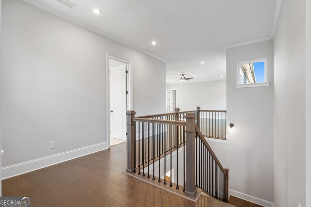 doorway with ceiling fan, wood finished floors, visible vents, baseboards, and ornamental molding