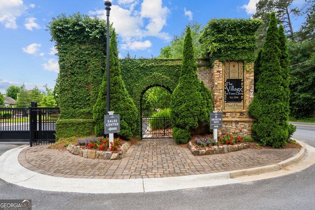 view of street with a gate, curbs, and a gated entry