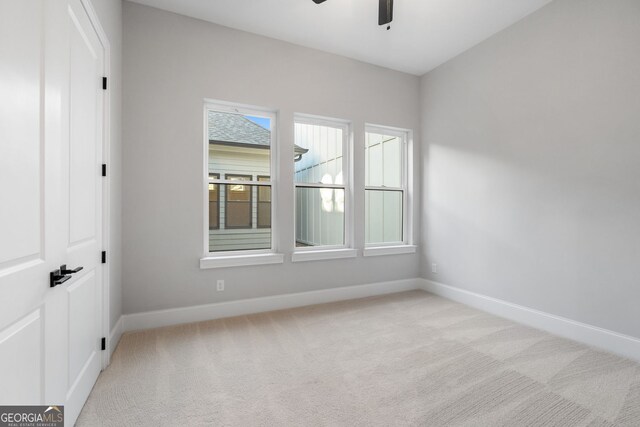 spare room with carpet, ceiling fan, and baseboards