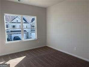 unfurnished room featuring baseboards and dark carpet