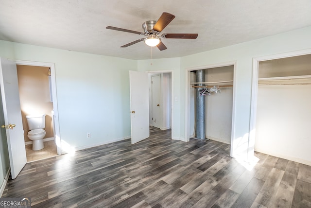 unfurnished bedroom featuring two closets, baseboards, a ceiling fan, and wood finished floors